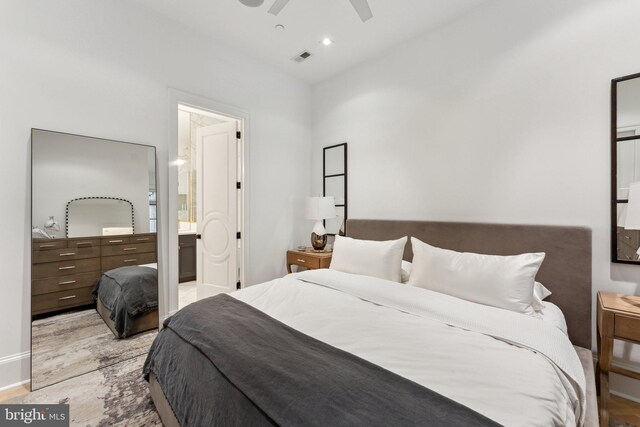 bedroom featuring wood finished floors, ensuite bath, and ceiling fan