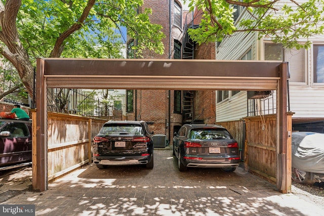 view of parking with fence and a carport