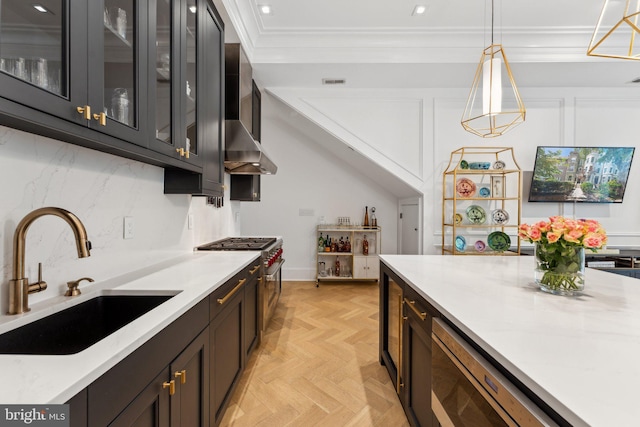kitchen with a sink, stainless steel stove, pendant lighting, glass insert cabinets, and ornamental molding