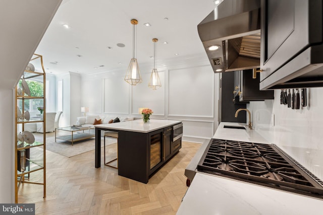 kitchen with wall chimney exhaust hood, stainless steel microwave, cooktop, a breakfast bar area, and a sink