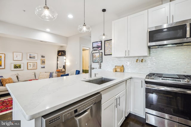 528 Kennedy St NW Unit 502, Washington, DC 20011 - kitchen with appliances with stainless steel finishes, a peninsula, a sink, tasteful backsplash, and dark wood-type flooring