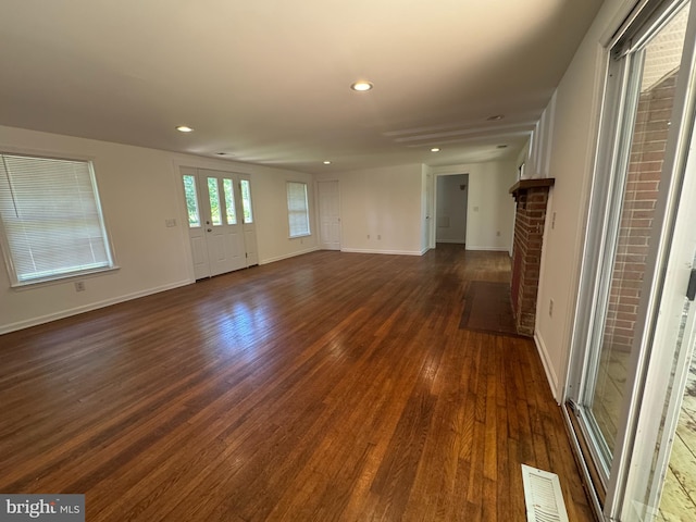 8888 Harmony Rd, Denton, MD 21629 - unfurnished living room featuring dark wood-style flooring, baseboards, recessed lighting, and a brick fireplace