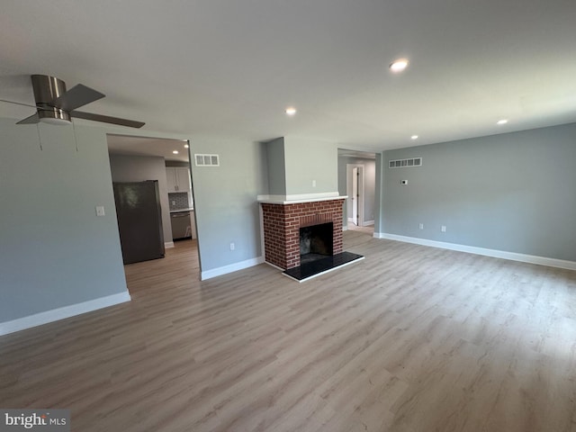 581 Milford Neck Rd, Milford, DE 19963 - unfurnished living room with recessed lighting, light wood-style flooring, baseboards, a brick fireplace, and ceiling fan