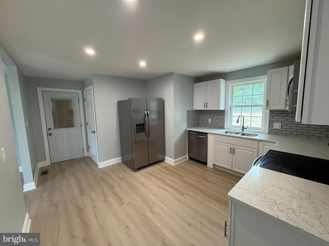 581 Milford Neck Rd, Milford, DE 19963 - kitchen with refrigerator with ice dispenser, stainless steel dishwasher, a sink, baseboards, and light wood finished floors