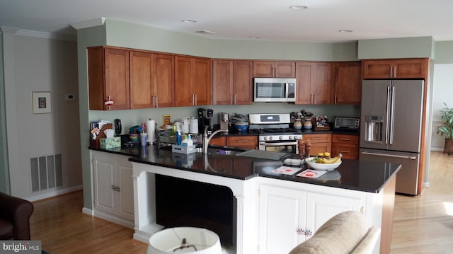 7501 Silver Maple Ln, Falls Church, VA 22042 - kitchen featuring appliances with stainless steel finishes, a sink, dark countertops, light wood-style flooring, and crown molding