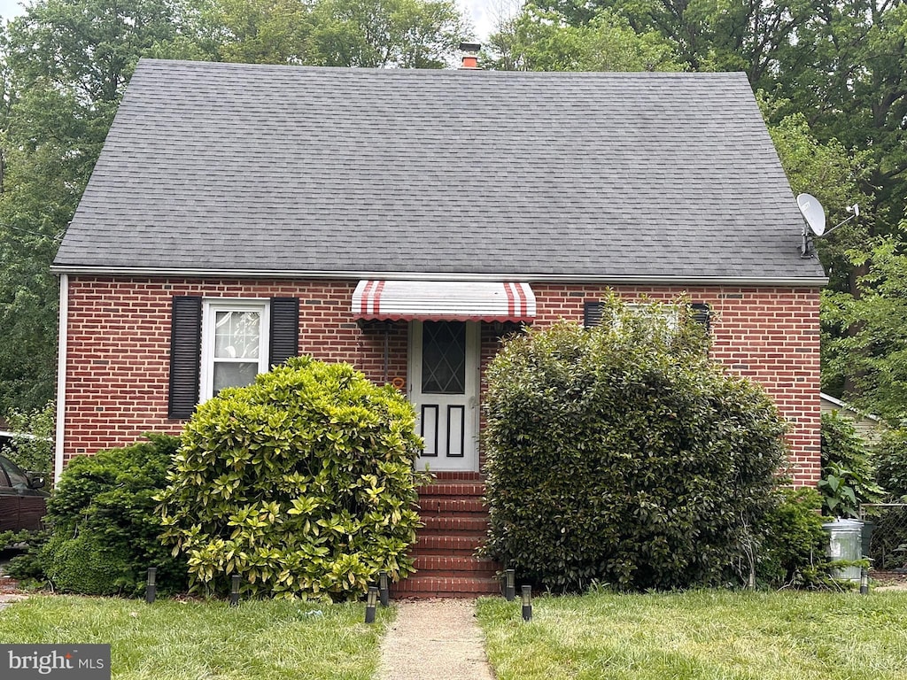 view of front of house featuring brick siding, a shingled roof, and entry steps