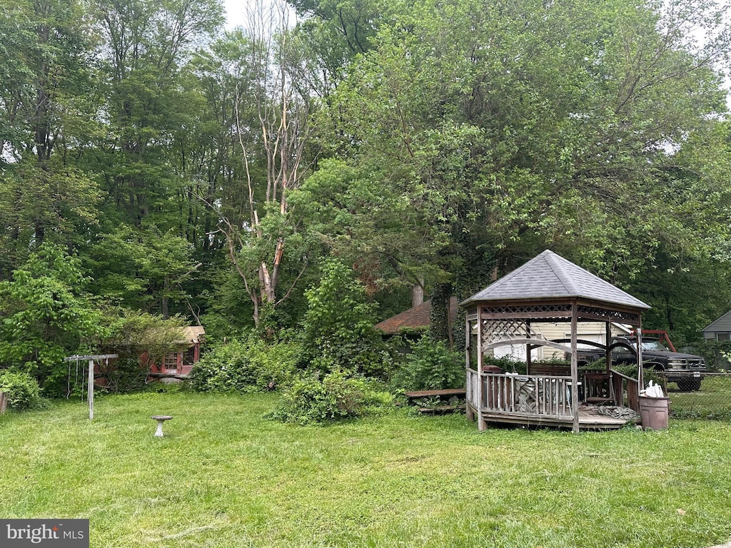 view of green lawn featuring a gazebo and a wooden deck