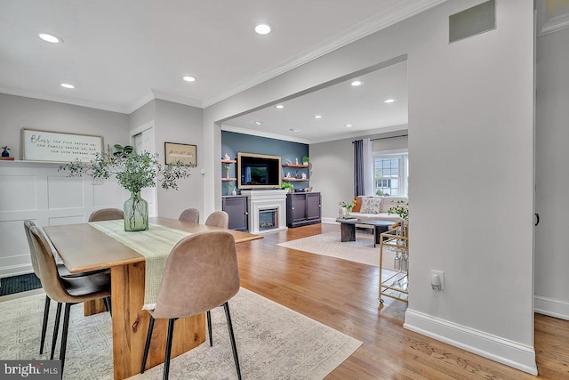 dining room featuring ornamental molding, light wood finished floors, recessed lighting, and baseboards