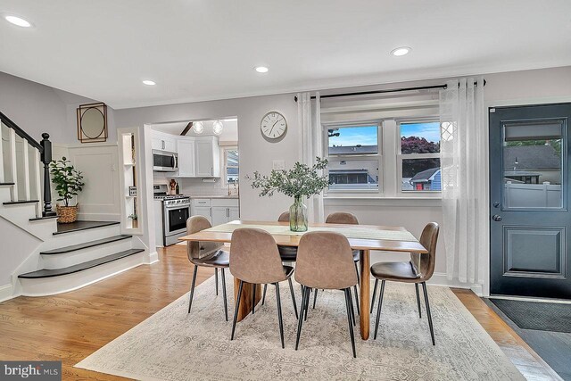 dining space featuring stairway, light wood-style flooring, and recessed lighting