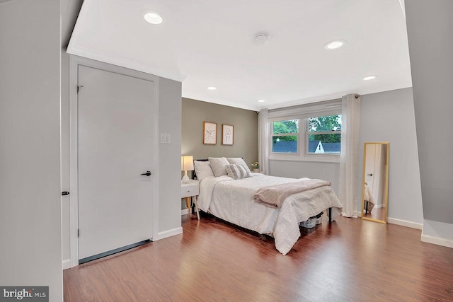 bedroom featuring wood finished floors, baseboards, recessed lighting, and crown molding