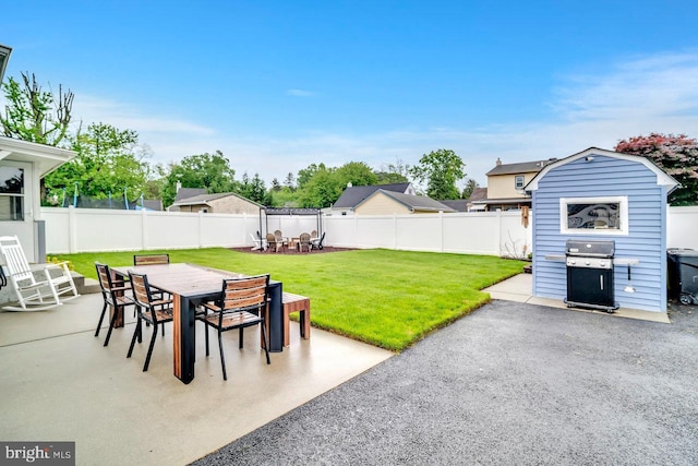 view of patio featuring outdoor dining space, a grill, a storage shed, and an outdoor structure