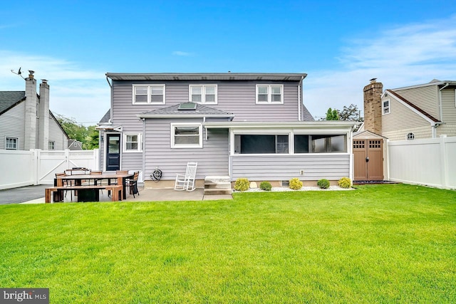 rear view of property with a patio area, a storage unit, an outbuilding, and a shingled roof