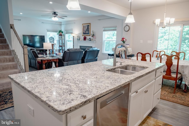8212 Hickory Hollow Dr, Glen Burnie, MD 21060 - kitchen featuring stainless steel dishwasher, a sink, a center island with sink, light wood-style floors, and ceiling fan