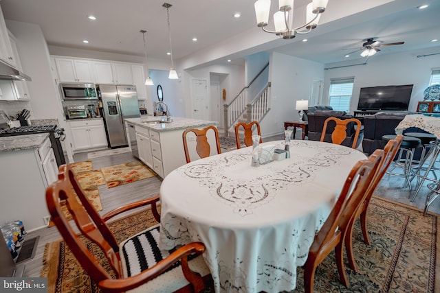 8212 Hickory Hollow Dr, Glen Burnie, MD 21060 - dining room featuring stairs, a ceiling fan, light wood-style flooring, recessed lighting, and a chandelier