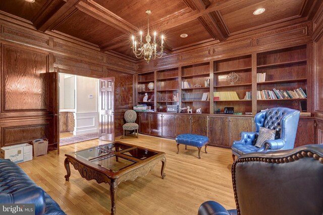 living area featuring wood ceiling, a chandelier, wooden walls, coffered ceiling, and beam ceiling