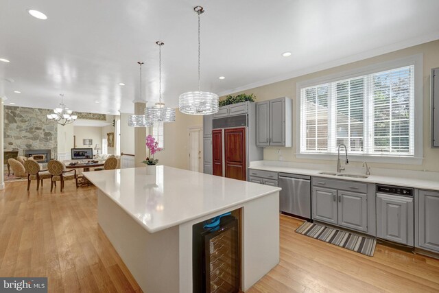 kitchen featuring dishwasher, a sink, gray cabinetry, wine cooler, and crown molding