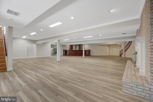 finished below grade area featuring stairway, baseboards, light wood-style floors, crown molding, and recessed lighting