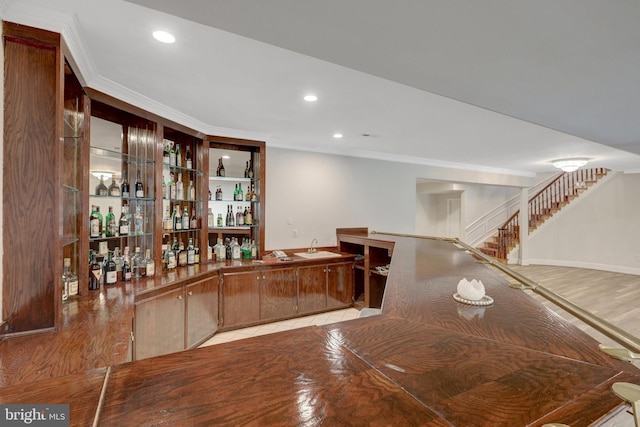 indoor wet bar with crown molding, stairs, and recessed lighting