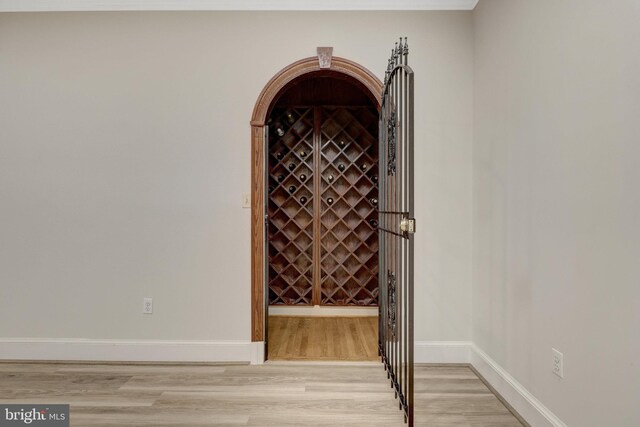 wine area with light wood finished floors and baseboards