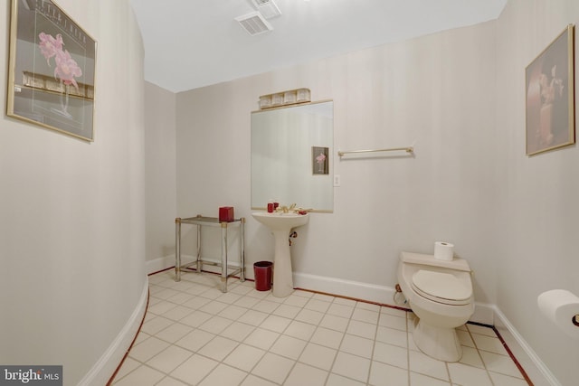 bathroom featuring toilet, tile patterned flooring, and baseboards
