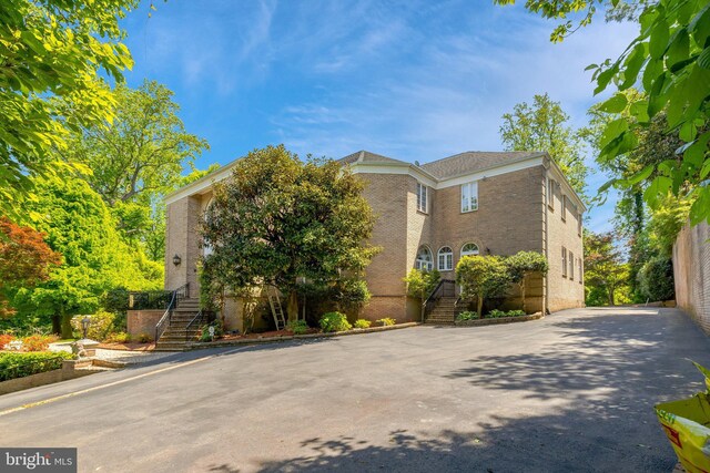 view of front of property with stairway and brick siding