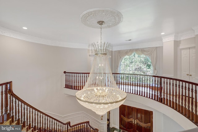 detailed view of a chandelier, ornamental molding, and recessed lighting