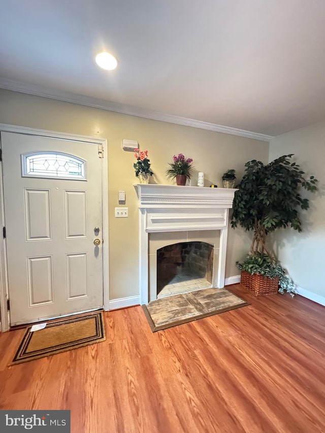 707 Mentor Ave, Capitol Heights, MD 20743 - entrance foyer with a tiled fireplace, ornamental molding, wood finished floors, and baseboards
