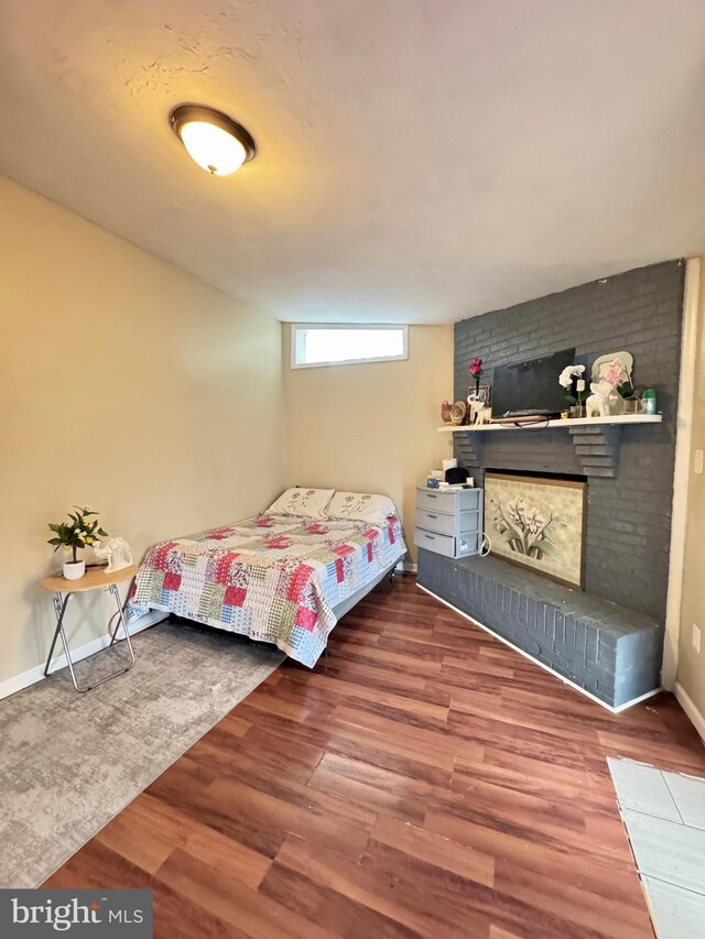 707 Mentor Ave, Capitol Heights, MD 20743 - bedroom featuring wood finished floors, a brick fireplace, and baseboards