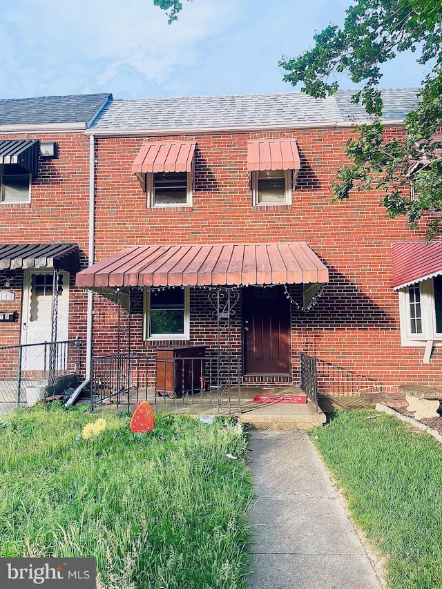 437 52nd St, Baltimore, MD 21224 - view of front of home featuring brick siding, a shingled roof, and fence