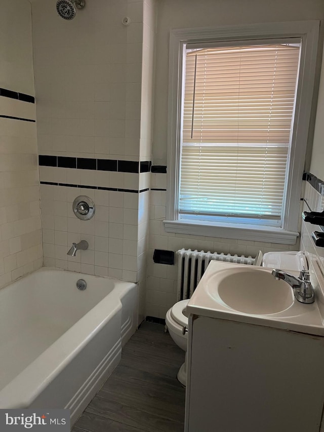 437 52nd St, Baltimore, MD 21224 - bathroom featuring toilet, wood finished floors, radiator heating unit, a bath, and vanity