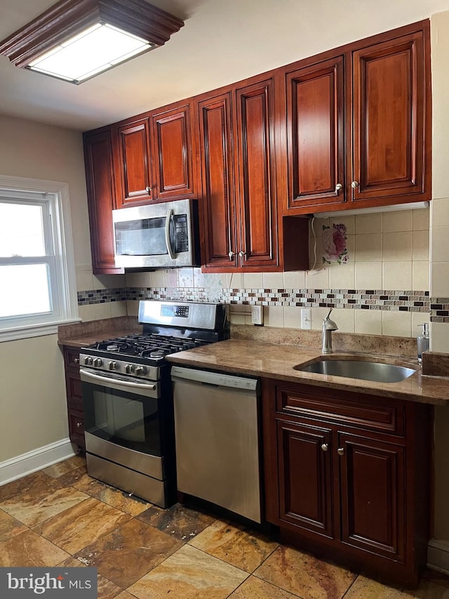 437 52nd St, Baltimore, MD 21224 - kitchen with appliances with stainless steel finishes, backsplash, reddish brown cabinets, and a sink