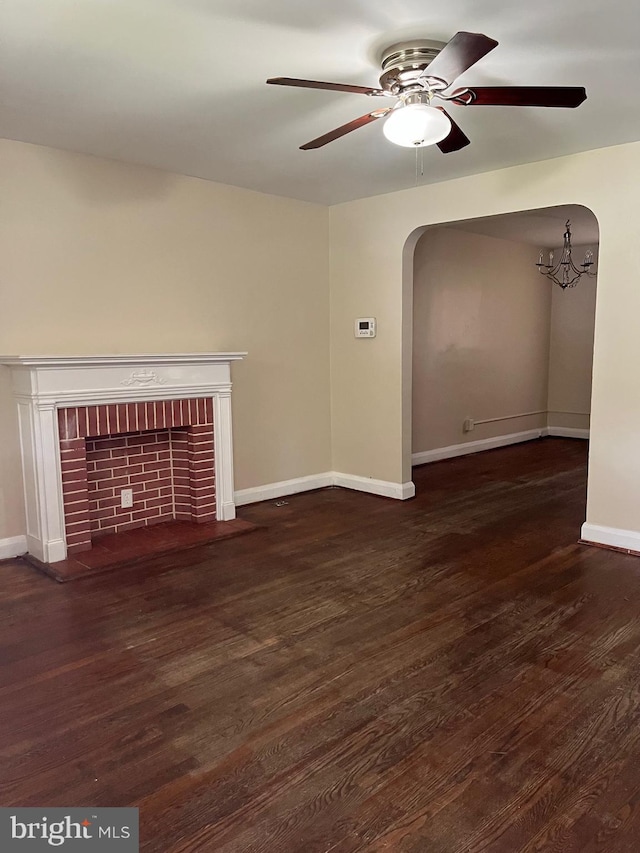 437 52nd St, Baltimore, MD 21224 - unfurnished living room featuring arched walkways, ceiling fan, wood finished floors, a fireplace, and baseboards