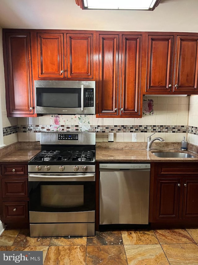 437 52nd St, Baltimore, MD 21224 - kitchen with stainless steel appliances, a sink, dark brown cabinets, and backsplash