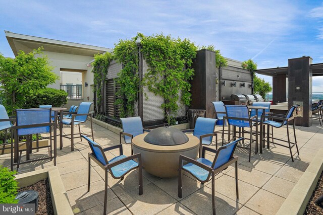 851 N Glebe Rd Unit 406, Arlington, VA 22203 - view of patio / terrace with a fire pit, outdoor dining area, and an outdoor kitchen