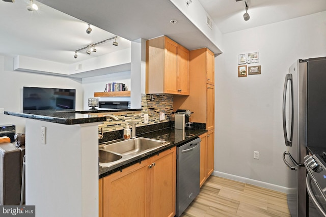 851 N Glebe Rd Unit 406, Arlington, VA 22203 - kitchen featuring appliances with stainless steel finishes, track lighting, a sink, light wood finished floors, and decorative backsplash