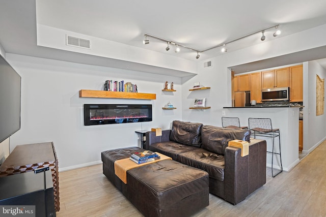 851 N Glebe Rd Unit 406, Arlington, VA 22203 - living area featuring light wood-type flooring, baseboards, and a glass covered fireplace