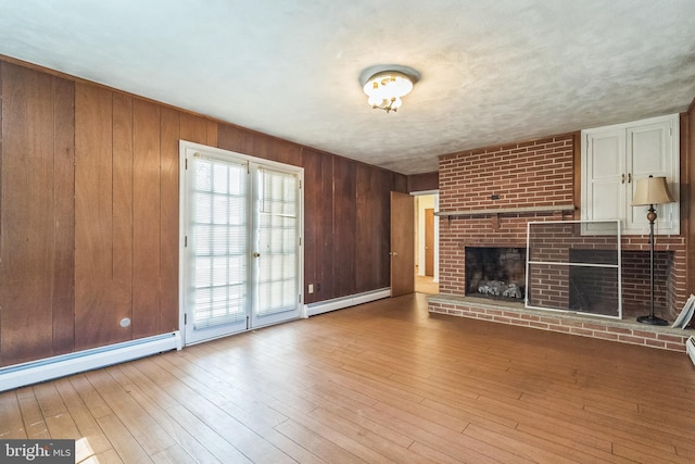 800 Little Shiloh Rd, West Chester, PA 19382 - unfurnished living room with a baseboard radiator, a fireplace, wood finished floors, and wooden walls