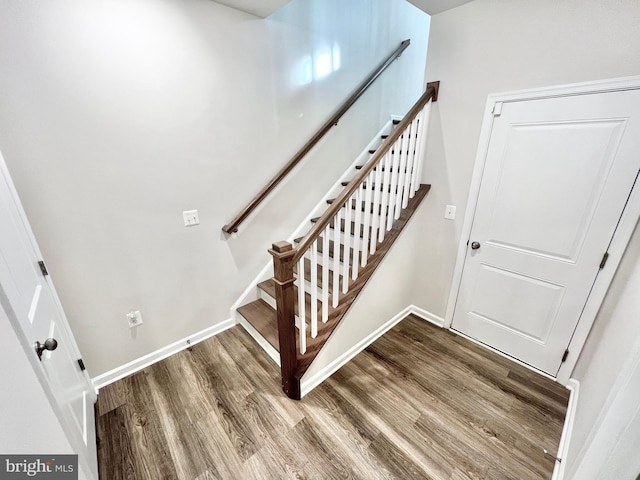 stairs with wood finished floors and baseboards