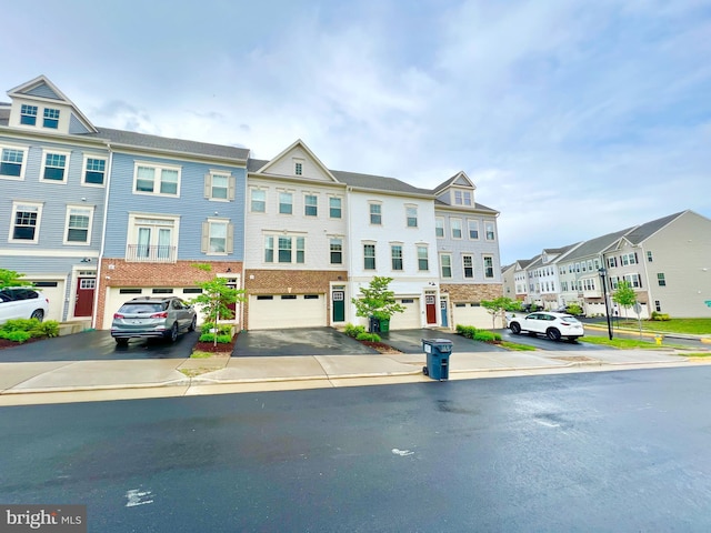 multi unit property with a residential view, an attached garage, and driveway