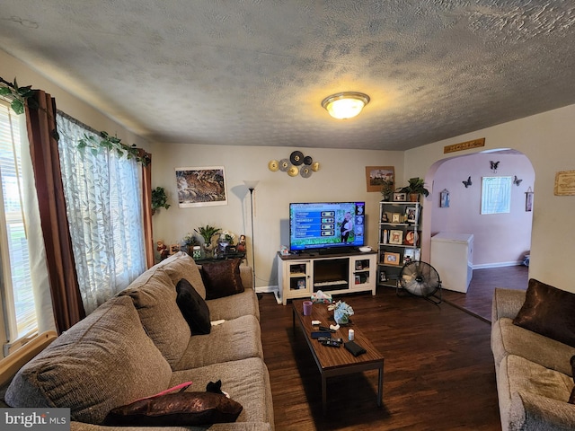 1351 Cambria St, Baltimore, MD 21225 - living room featuring arched walkways, healthy amount of natural light, wood finished floors, baseboards, and a textured ceiling