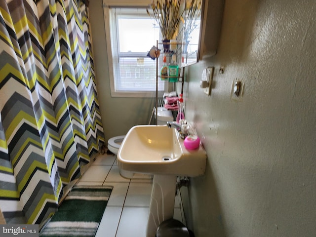 1351 Cambria St, Baltimore, MD 21225 - bathroom with tile patterned floors, a shower with shower curtain, a sink, and toilet