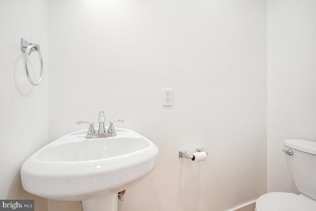 1706 Otis St NE, Washington, DC 20018 - bathroom with toilet, a sink, and baseboards