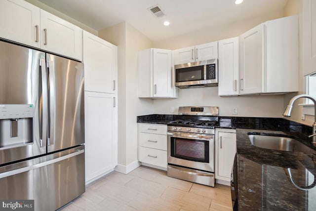 1706 Otis St NE, Washington, DC 20018 - kitchen with stainless steel appliances, a sink, white cabinets, dark stone countertops, and recessed lighting