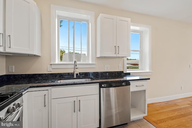 1706 Otis St NE, Washington, DC 20018 - kitchen with stainless steel appliances, a sink, white cabinetry, and light wood finished floors
