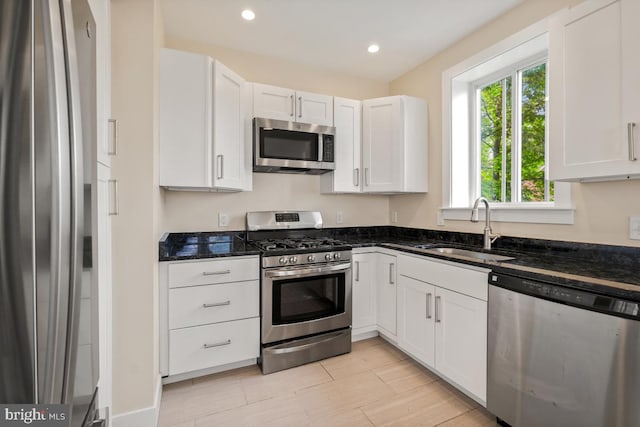 1706 Otis St NE, Washington, DC 20018 - kitchen featuring stainless steel appliances, a sink, dark stone counters, white cabinets, and recessed lighting