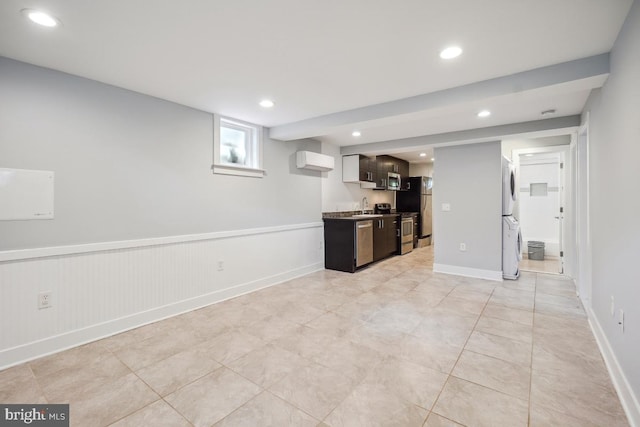 1706 Otis St NE, Washington, DC 20018 - unfurnished living room featuring stacked washer / dryer, an AC wall unit, a sink, recessed lighting, and light tile patterned floors