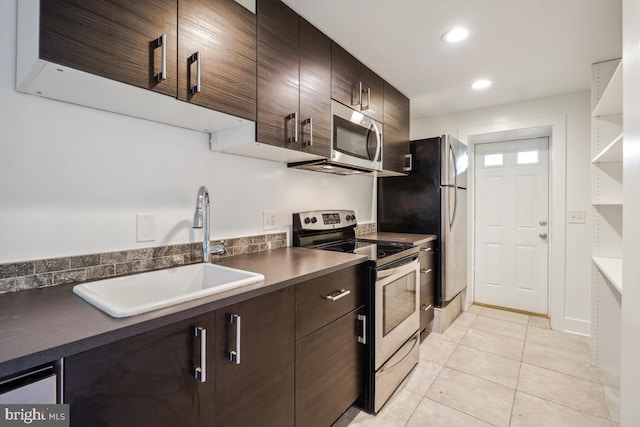 1706 Otis St NE, Washington, DC 20018 - kitchen with appliances with stainless steel finishes, a sink, light tile patterned floors, dark brown cabinets, and dark countertops