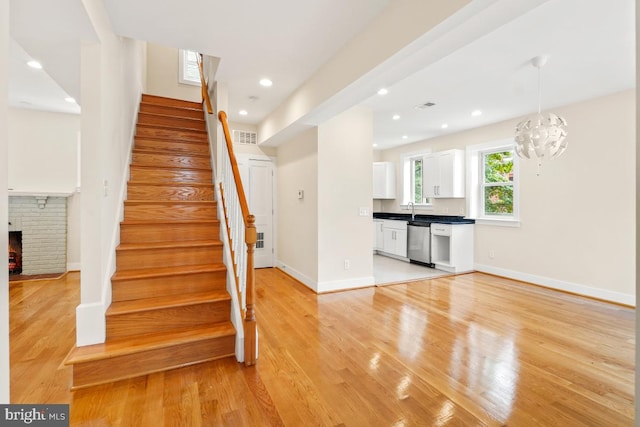 1706 Otis St NE, Washington, DC 20018 - stairs featuring wood finished floors, baseboards, a brick fireplace, and recessed lighting