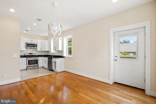 1706 Otis St NE, Washington, DC 20018 - kitchen with stainless steel appliances, baseboards, dark countertops, white cabinets, and recessed lighting