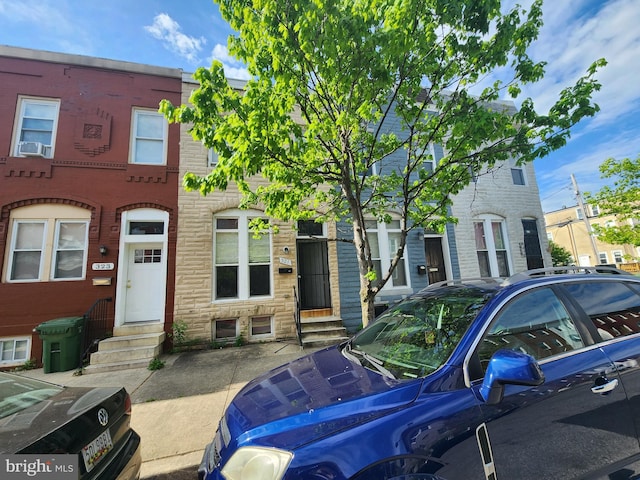 321 E 21st St, Baltimore, MD 21218 - townhome / multi-family property featuring entry steps, stone siding, and cooling unit